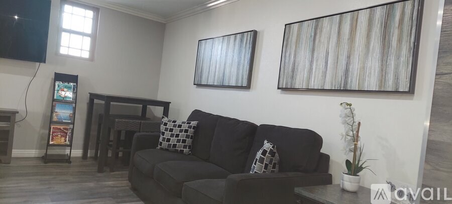 A living room with a black couch and a coffee table.