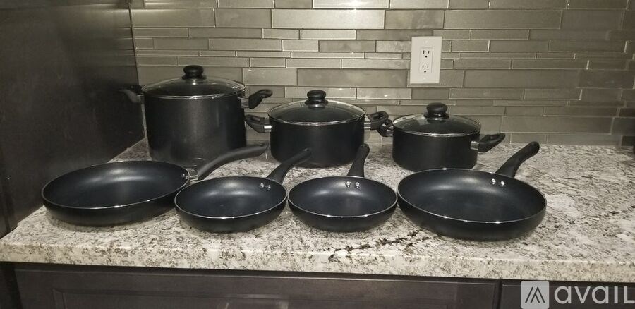 A set of cookware including pots and pans are displayed on a counter.