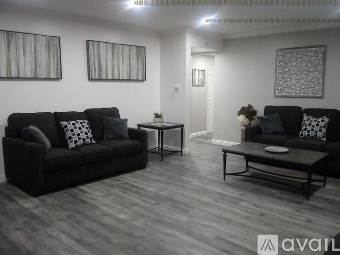 A living room with a black couch and a coffee table.