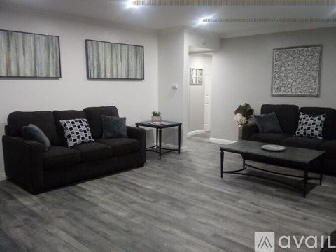A living room with a black couch and a coffee table.