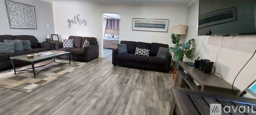 A living room with a couch, coffee table, and a TV.