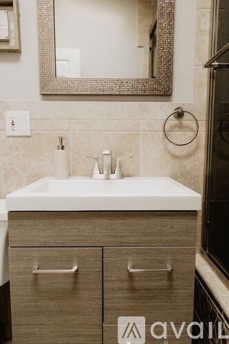 A bathroom with a sink, mirror, and cabinets.