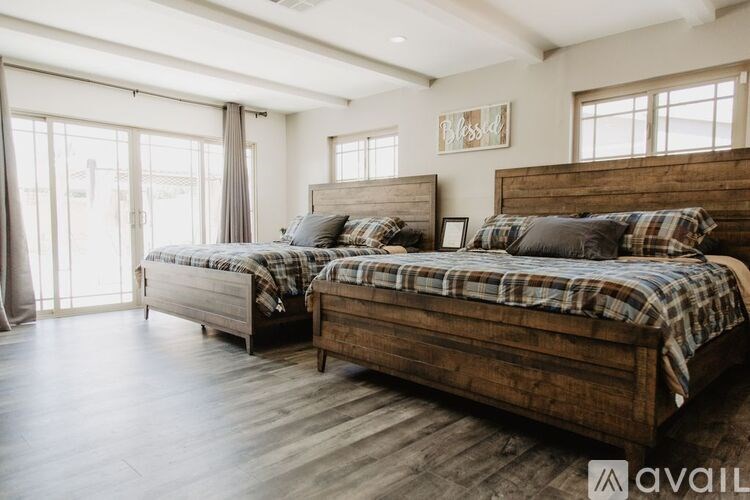 A bedroom with two beds and wooden floors.