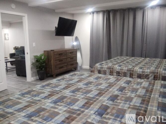 A bedroom with a bed, a dresser, and a chair.