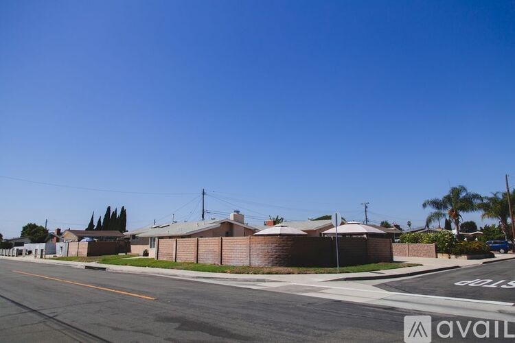 A street view with houses and a clear blue sky.