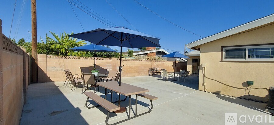 A patio with a table and chairs under an umbrella.