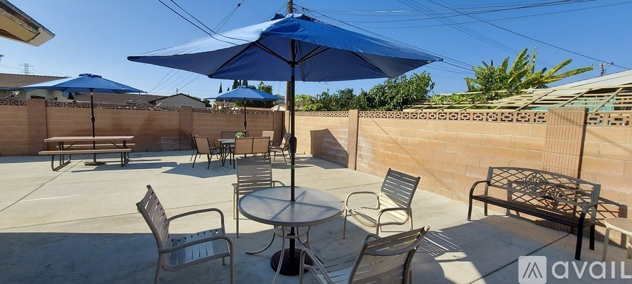 A patio with a table and chairs under an umbrella.
