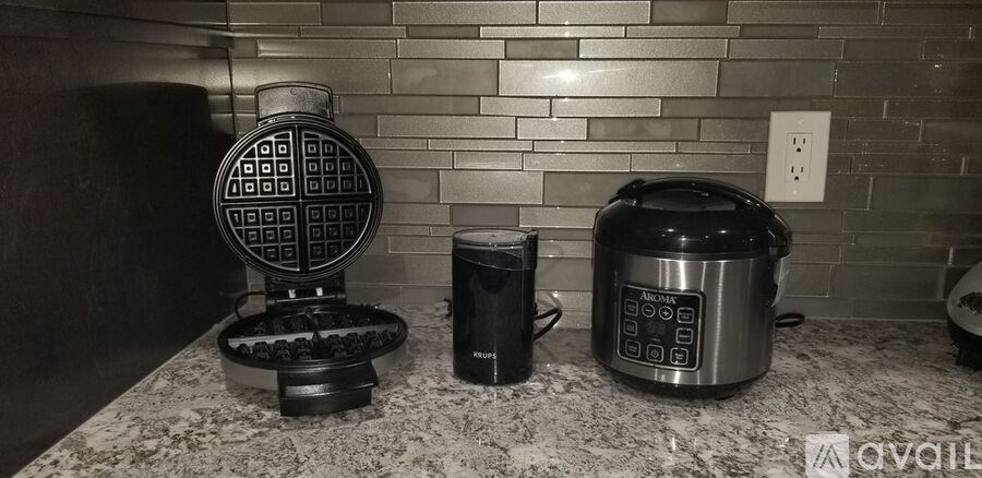A kitchen counter with a waffle maker, a toaster oven, and a slow cooker.