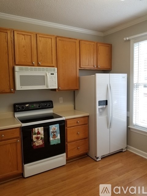 A kitchen with wooden cabinets and a white fridge.