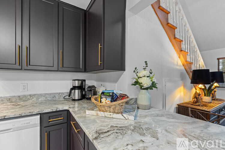 A kitchen with black cabinets and a marble countertop.