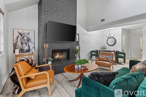 A living room with a fireplace and a television mounted above it.