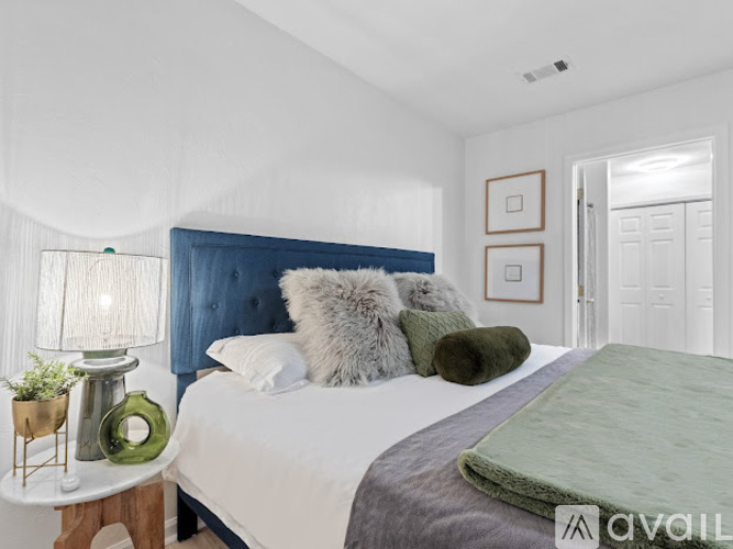 A bedroom with a white bed and a blue headboard.