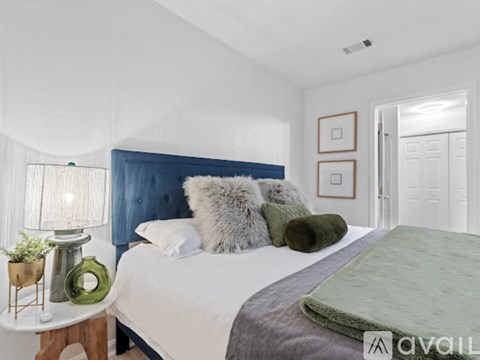A bedroom with a white bed and a blue headboard.