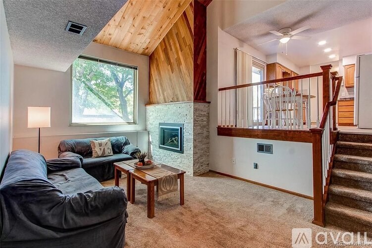 A living room with a couch, a coffee table, and a fireplace.