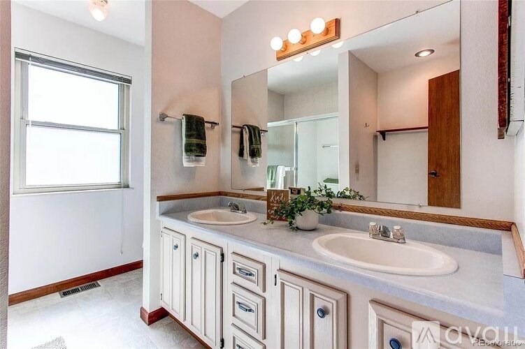 A bathroom with a sink, mirror, and a window.