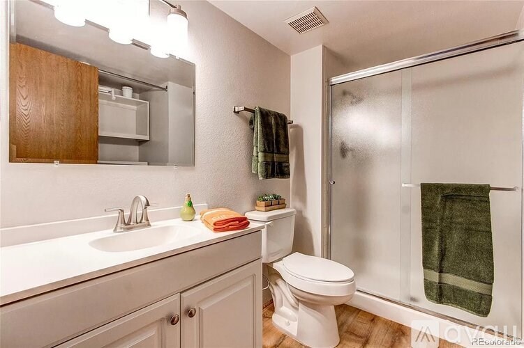 A white toilet sits next to a sink in a small bathroom.