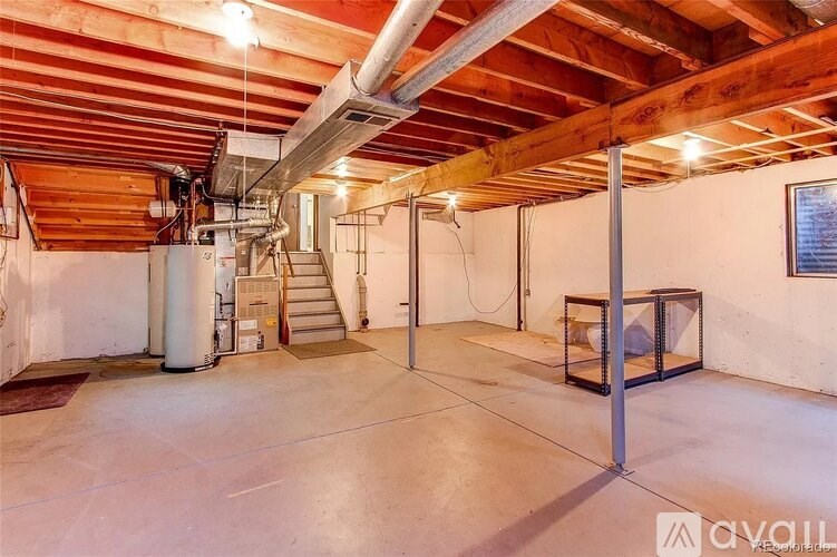 A spacious room with wooden ceiling and a staircase.