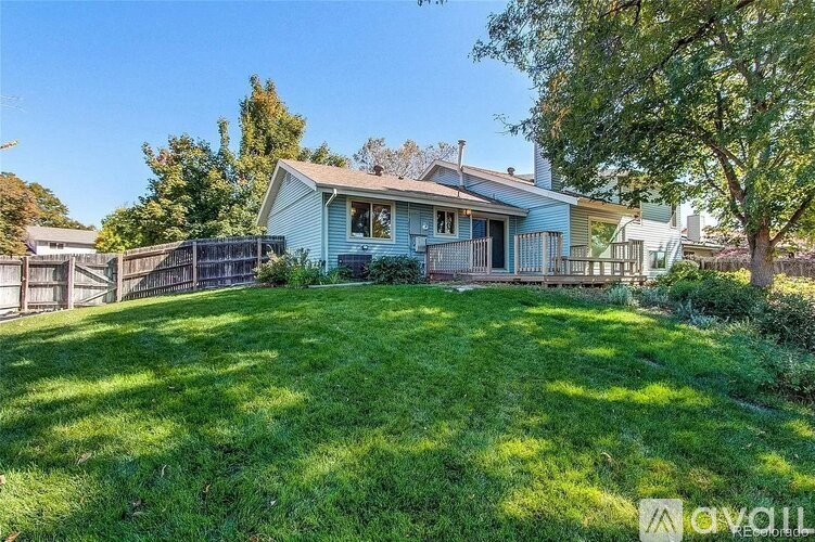 A house with a blue roof and a green lawn in front.