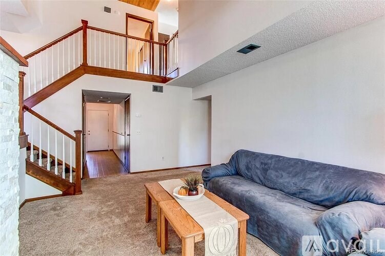 A living room with a blue couch and a wooden coffee table.