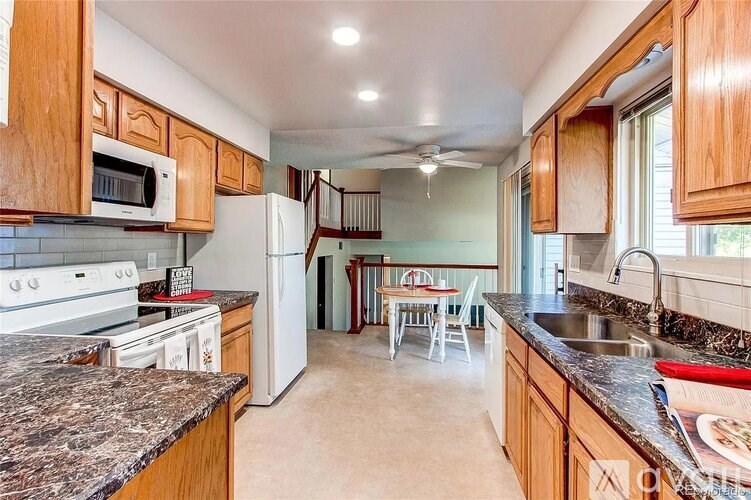 A kitchen with granite countertops and wooden cabinets.