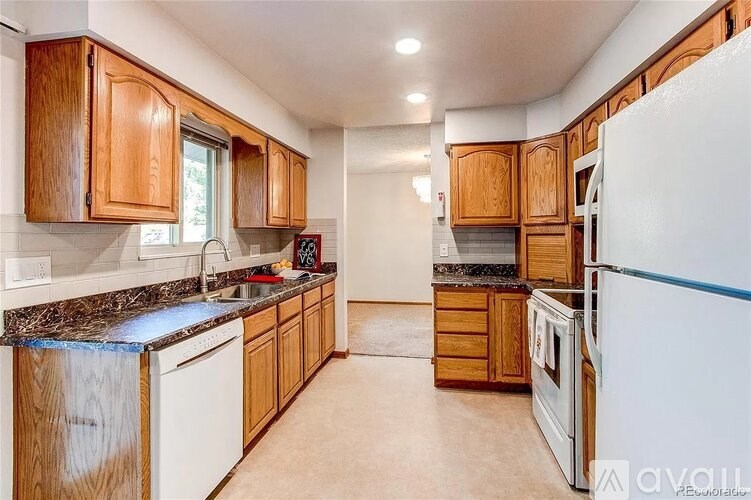 A kitchen with wooden cabinets and a white refrigerator.