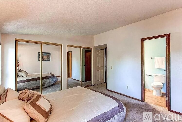 A bedroom with a large bed and a mirror on the wall.