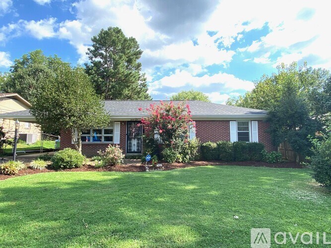A house with a red brick exterior and a green lawn.