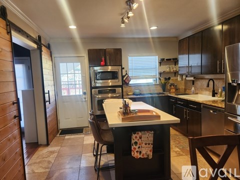 A kitchen with a table and chairs in front of a refrigerator.