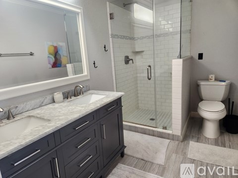 A bathroom with a sink, toilet, and shower.