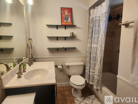 A bathroom with a toilet, sink, and shelves.
