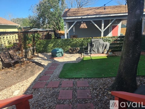 A backyard with a red brick walkway and a green lawn.