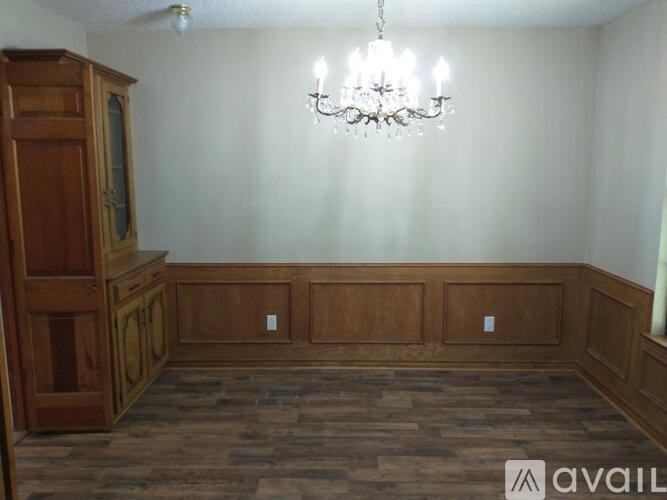 A room with wooden floors and a chandelier hanging from the ceiling.