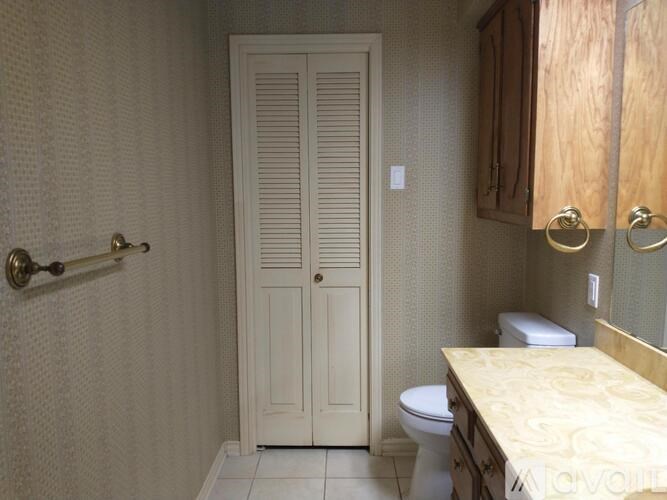 A white bathroom with a toilet, sink, and a door.