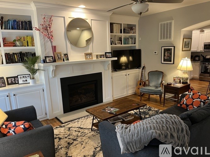 A living room with a fireplace, a chair, a couch, and a TV.