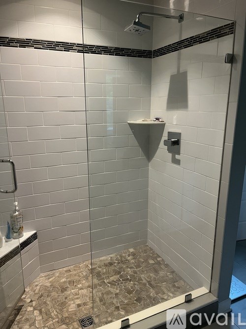 A bathroom with a walk in shower and a tiled floor.