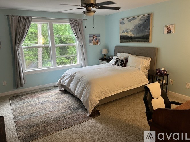A bedroom with a large bed and a ceiling fan.