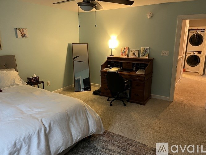 A bedroom with a bed, desk, and chair.