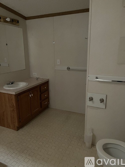 A bathroom with a toilet, sink, and medicine cabinet.