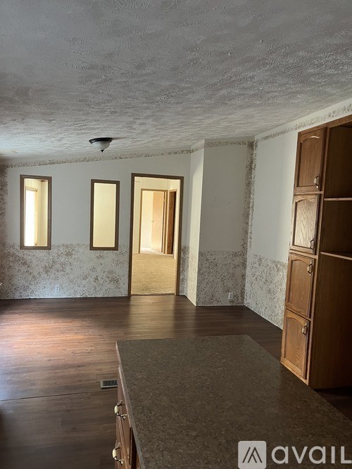 A room with wooden floors and a wall with a patterned wallpaper.