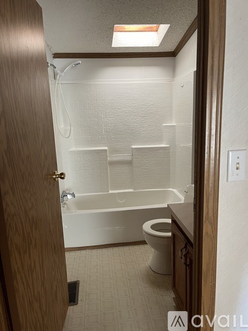 A small bathroom with a toilet, tub, and shower.