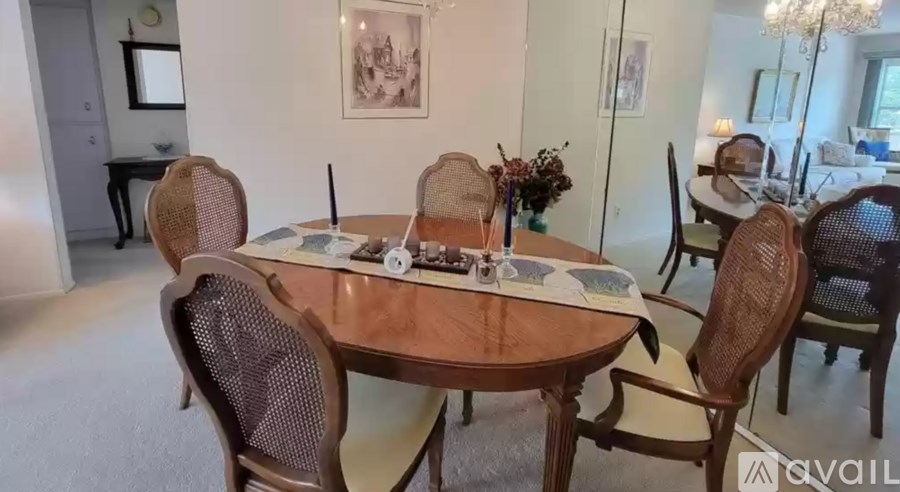 A dining table surrounded by chairs with a vase of flowers on the table.