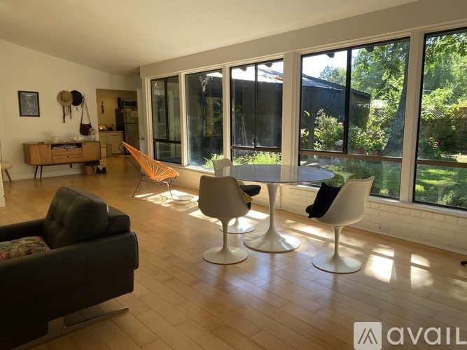 A living room with a hammock and three chairs.