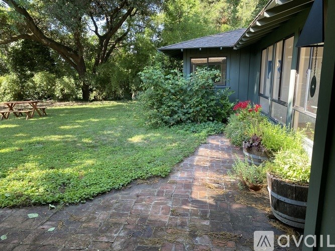 A backyard with a brick walkway and a picnic table.