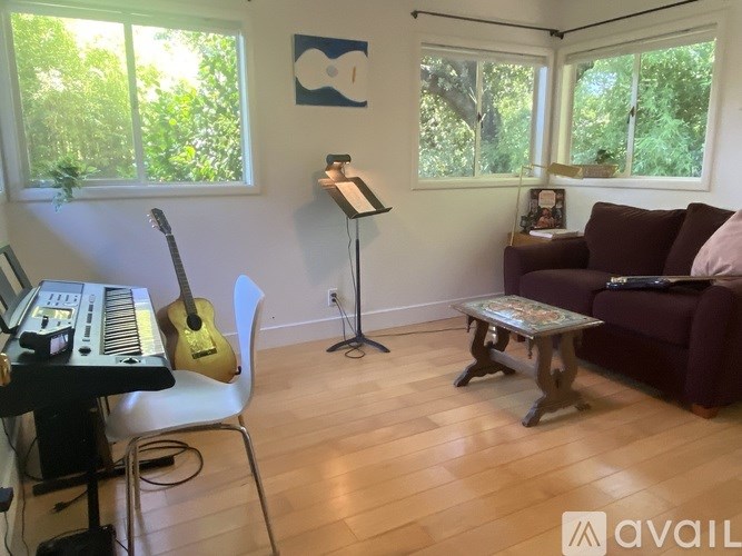 A room with a piano, guitar, and a couch.