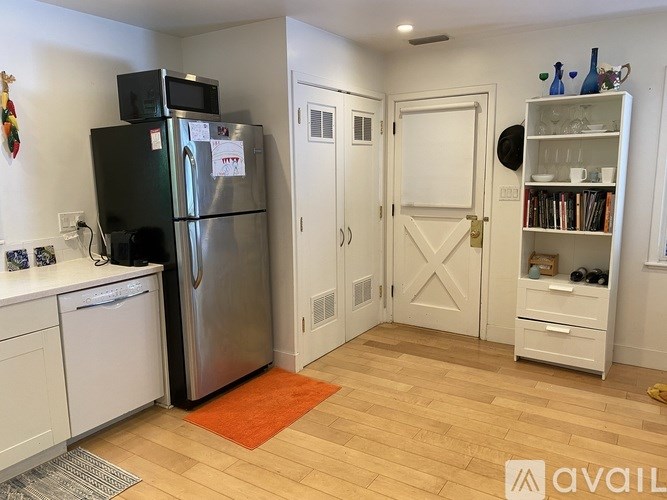 A kitchen with a black fridge and white cabinets.