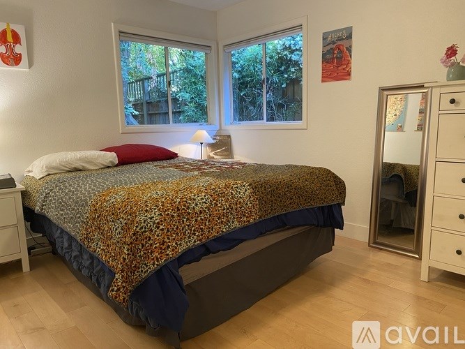 A bedroom with a bed, a dresser, and a window.