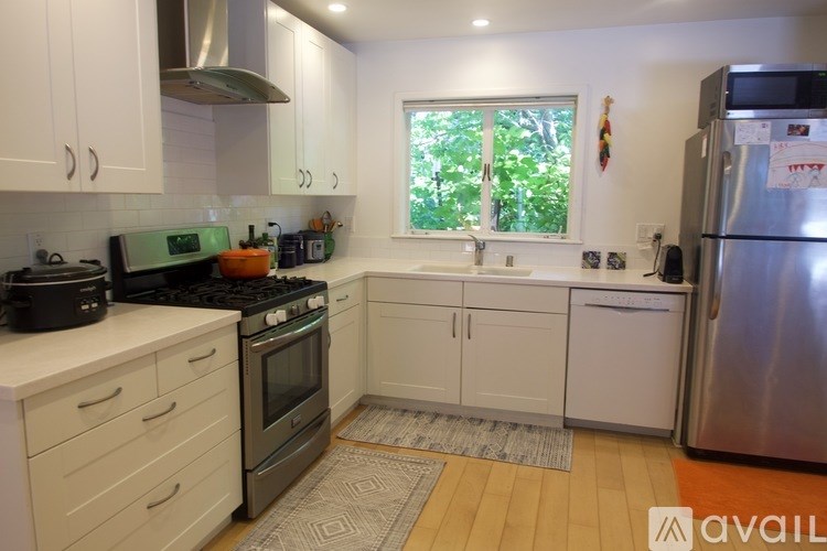 A kitchen with white cabinets and a stainless steel refrigerator.