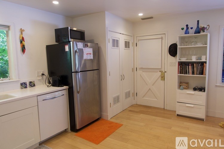 A kitchen with a black fridge and a white door.
