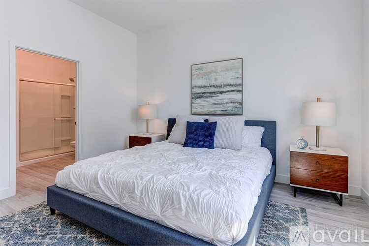 A bedroom with a large bed and a painting on the wall.