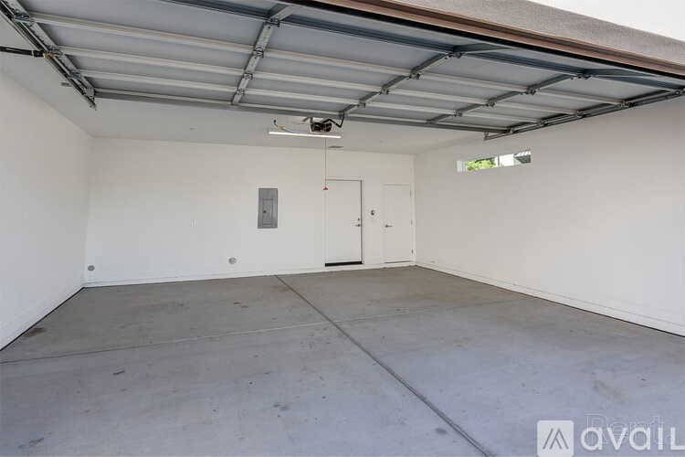 A spacious garage with a closed door and a ceiling fan.